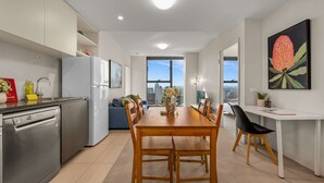 Una cocina moderna con comedor, un ventanal con vistas a la ciudad y un escritorio con computadora.