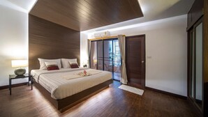 Une chambre moderne avec un grand lit, une table de chevet, un luminaire au plafond, une porte-fenêtre coulissante et une vue sur l’extérieur.