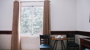 A room with a window, two chairs, a small table with a cup and saucer, and a bed. - HUNG HUONG HOTEL (Ho Chi Minh City)