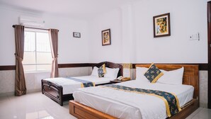 A hotel room with two beds, a window with curtains, a wall clock, and framed artwork. - HUNG HUONG HOTEL (Ho Chi Minh City)