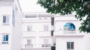 The entrance to Hotel Hung Huong with a prominent sign, a covered entrance, and a small outdoor seating area. - HUNG HUONG HOTEL (Ho Chi Minh City)
