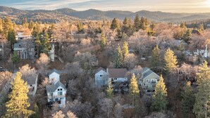 A residential area with houses surrounded by trees and hills in the background. - 2 Decks, Views, Firepit | Cozy Modern & Relaxing Home | Blue Spruce by AvantStay (Lake Arrowhead)