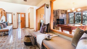A cozy living room with a stone fireplace, a pool table, and a comfortable seating area. - 3.5-Acre 5BDR Rereat w/ Views, Pool + Hot Tub, Fire Pit | Gable by AvantStay (Santa Rosa)