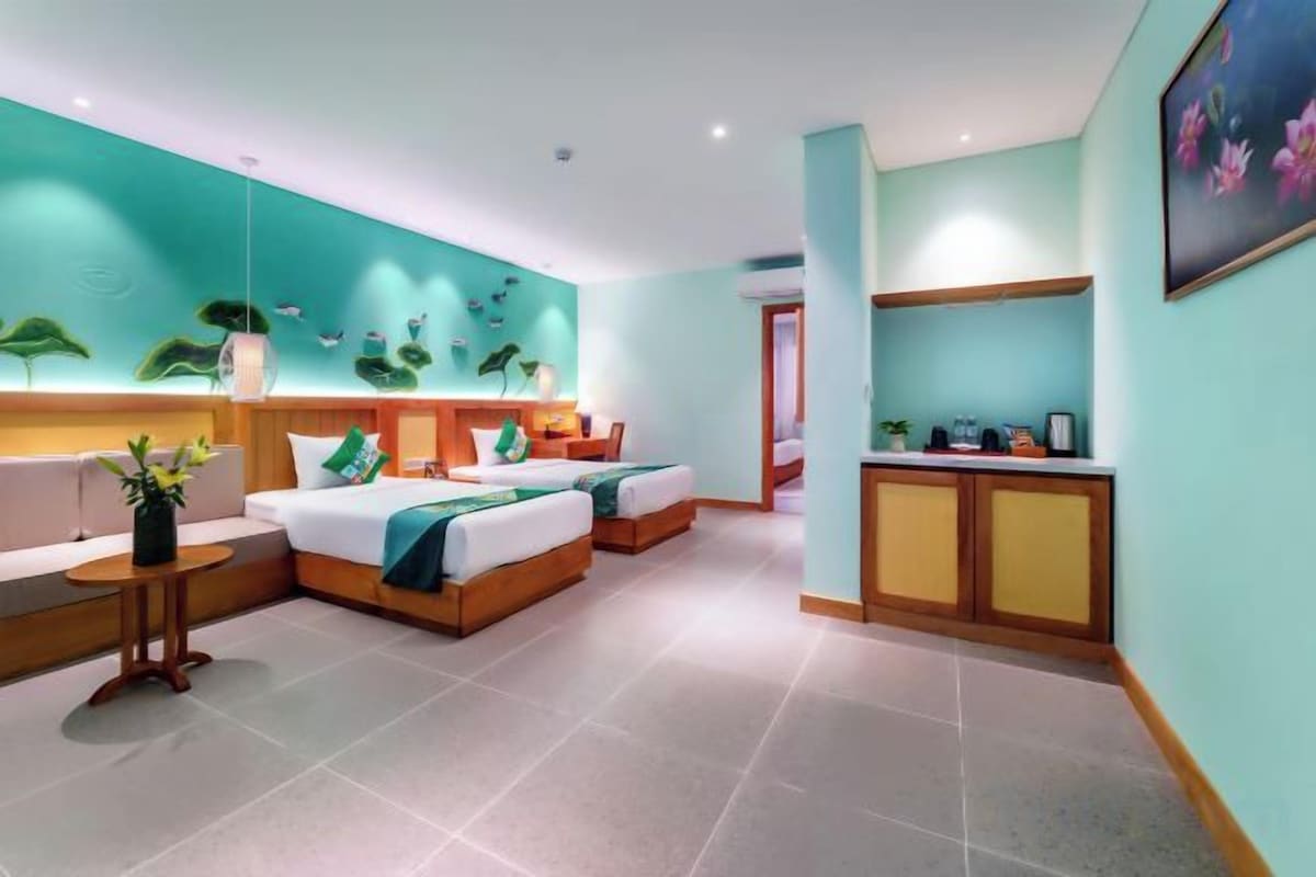 A hotel room with a bed, a sofa, a desk, and a bathroom.