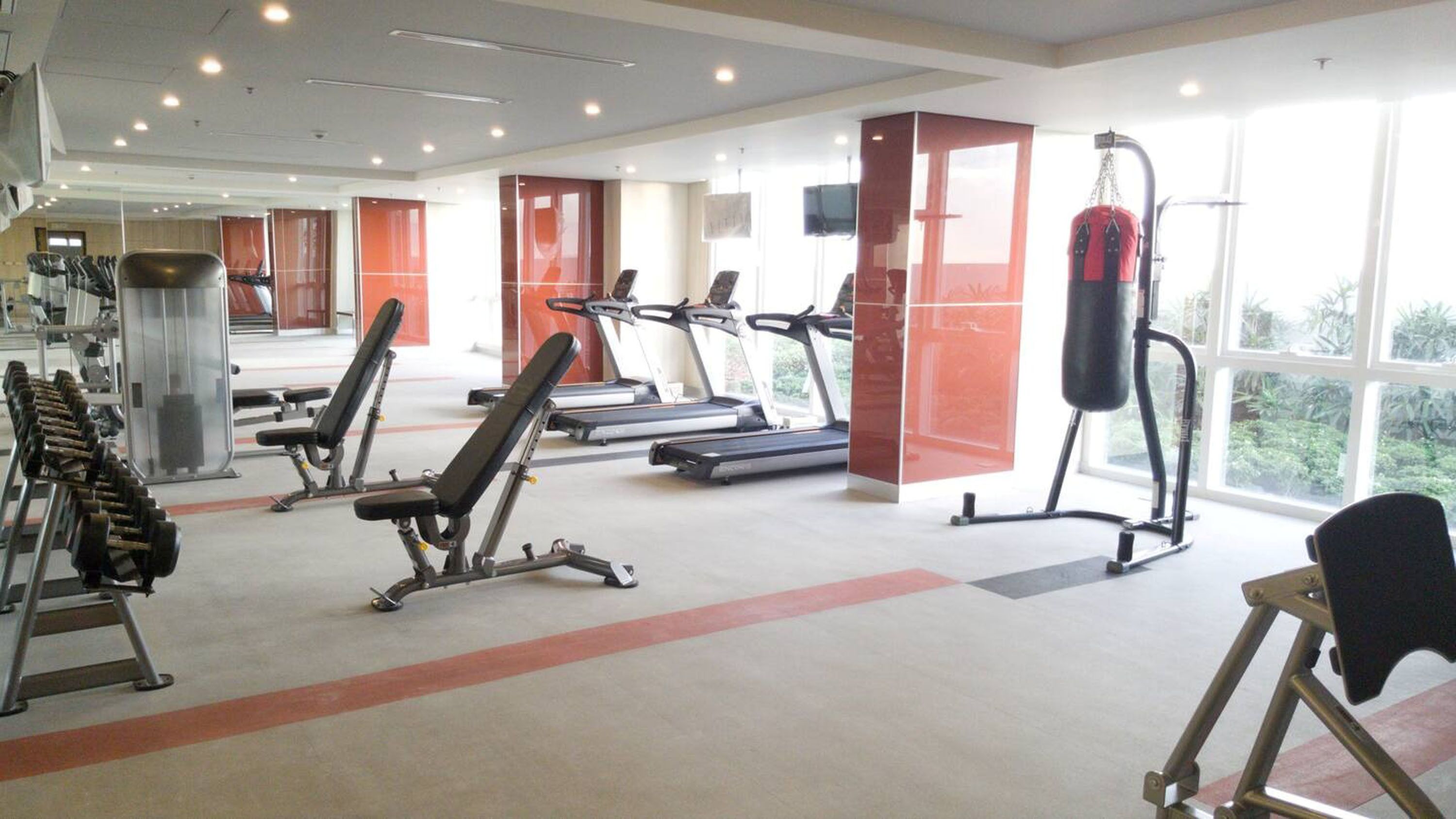 A gym with treadmills, weight machines, and a punching bag.