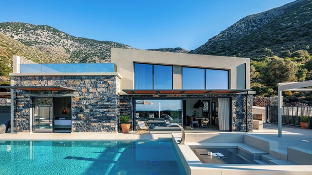 A modern house with a swimming pool, stone exterior, and a view of mountains. - Luxury Villa with Sea Views, Fire Pit & near beach (Rethymno)
