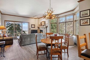 Cozy living room with fireplace, dining table, and seating area.