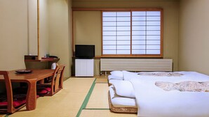 Une chambre d’hôtel avec un lit, un bureau et une chaise, une télévision et une fenêtre donnant sur un beau paysage.