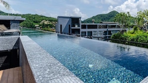 Un hôtel moderne doté d’une piscine, d’un espace couvert et offrant une vue sur un paysage verdoyant.