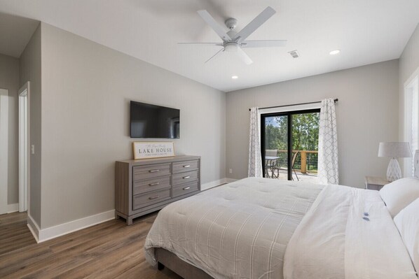 A bedroom with a bed, a ceiling fan, a TV, a dresser, and a sign that reads "Lake House". - Dock, Water Views, Kayaks, Fire Pit, Game Room (Winchester)