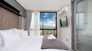 Une chambre d’hôtel moderne dotée d’un grand lit, offrant une vue sur la ville et équipée d’une télévision à écran plat.