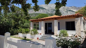 A building with a tiled roof, stone pillars, and a covered porch.