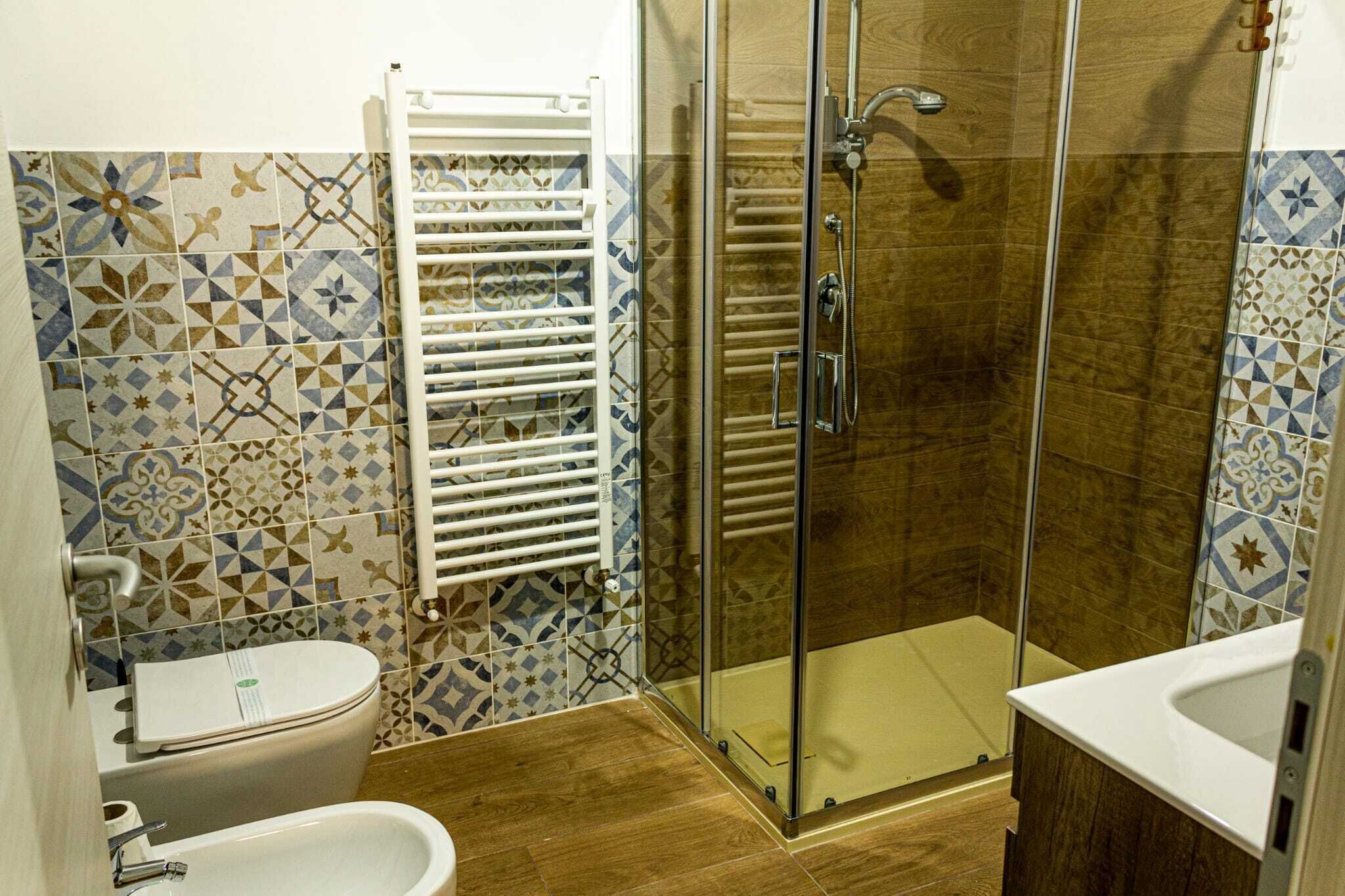 A bathroom with a glass-enclosed shower, a white toilet, and a bidet.