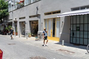 A building with a storefront, outdoor seating, and a bike parked outside. - Vintage Eclectic Loft by Sea N' Rent (Tel Aviv)