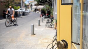 A yellow door with a sign reading "RABI HAMINA U" and a metal handle. - Vintage Eclectic Loft by Sea N' Rent (Tel Aviv)