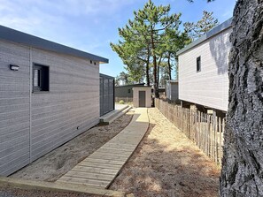 Una hilera de viviendas modulares con terraza de madera y zona amurallada.