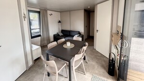 Un espacio habitable compacto con una mesa de comedor, sillas, un sofá y una lámpara.