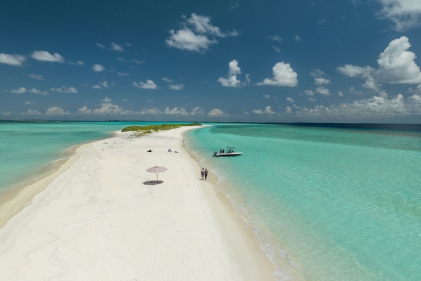 Una playa cerca, arena blanca, sillas reclinables de playa