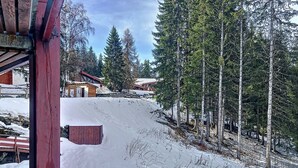 Paisaje nevado con una cabaña de madera y un telesilla.