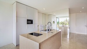 A modern kitchen with a central island, a built-in microwave, and a sink with a faucet.