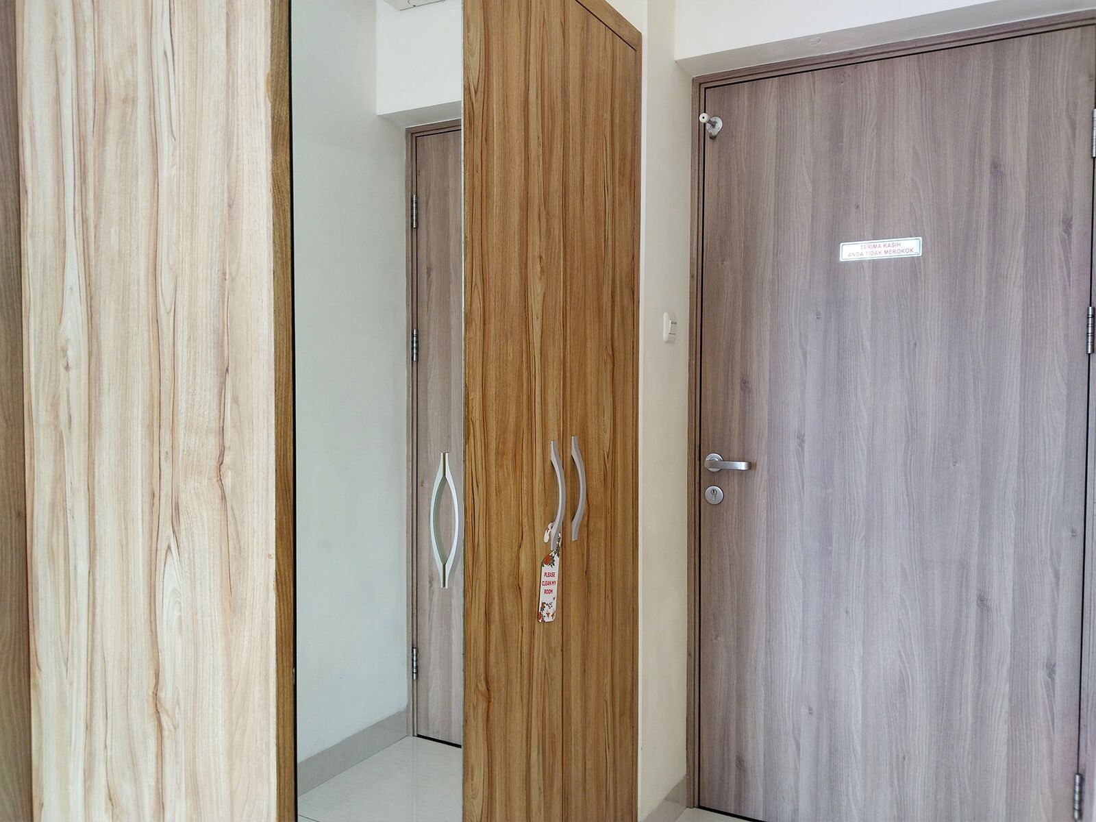Un pasillo con tres puertas de madera, cada una con un diseño diferente en la veta.