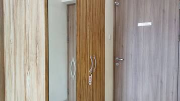 Un pasillo con tres puertas de madera, cada una con un diseño diferente en la veta.