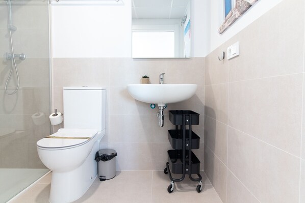 Une salle de bain moderne équipée de toilettes, d’un lavabo et d’une douche.