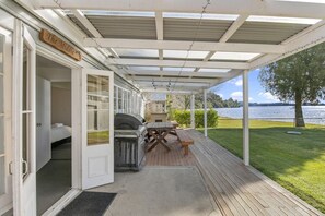 A covered outdoor area with a grill, picnic table, and a door labeled 'The Middle.'