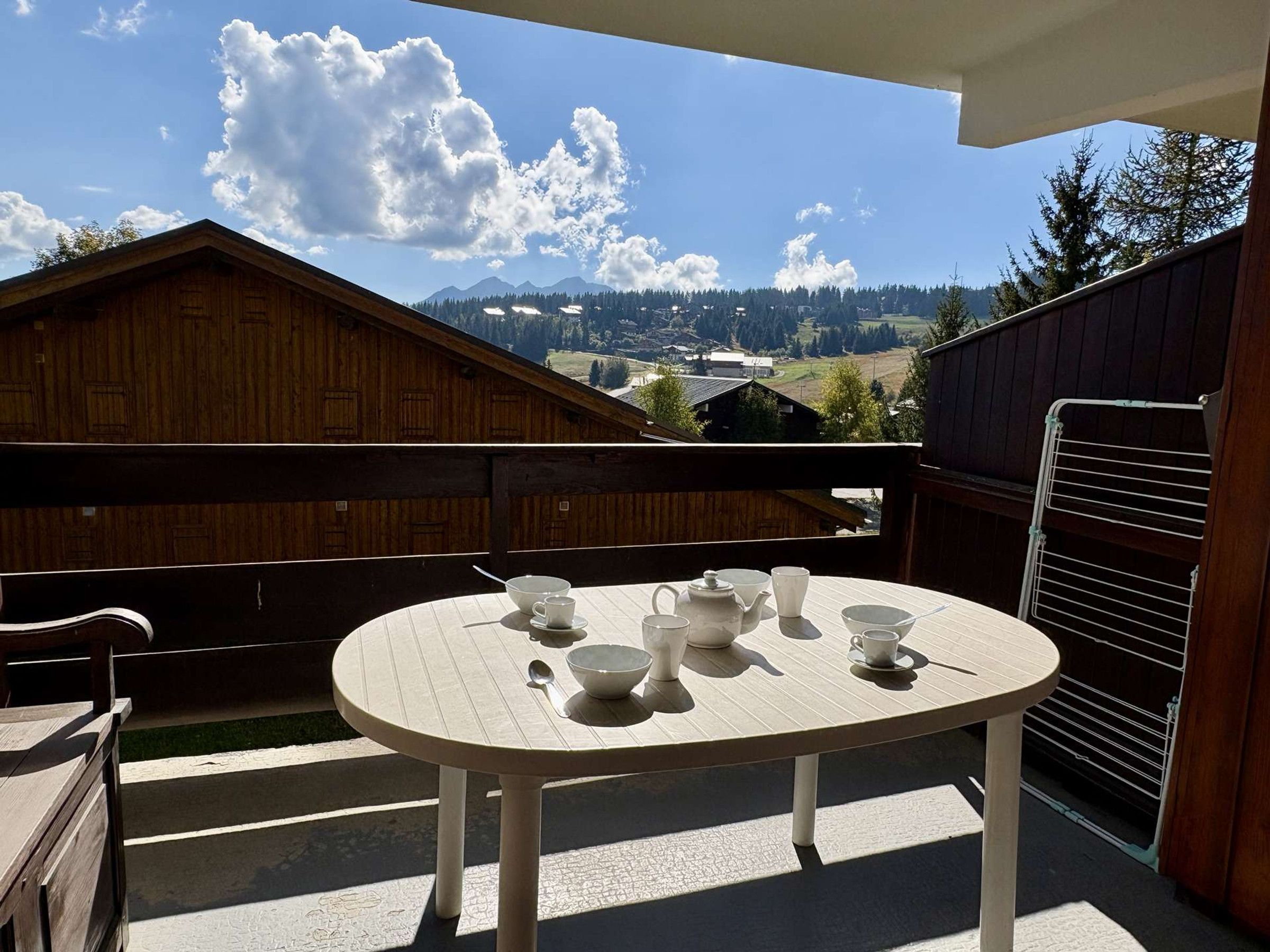 A round table with a view of mountains and a wooden building.