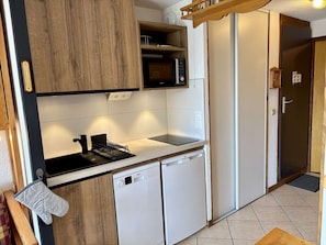 A compact kitchen with a microwave, stove, and dishwasher.