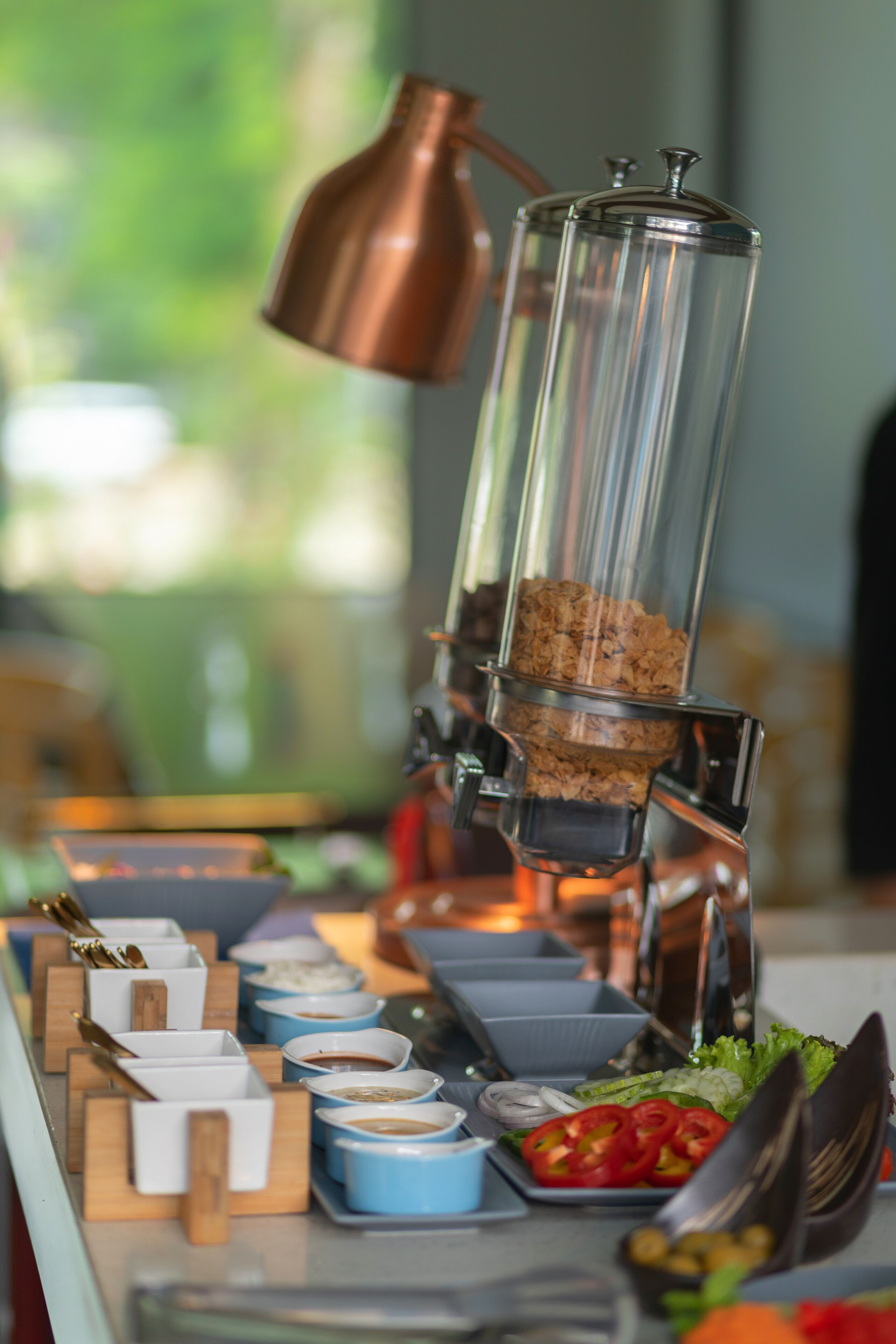 A coffee station with a coffee grinder, cups, and condiments.