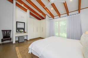 Ein Schlafzimmer mit Bett, Schreibtisch, Spiegel, Stuhl und Kleiderschrank.