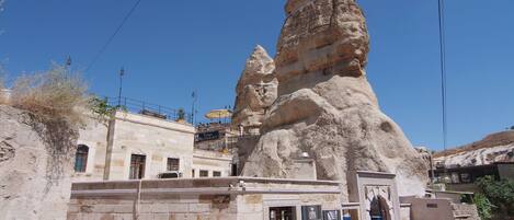 A building with a unique rock-like structure, a restaurant sign, and a wine bar sign.