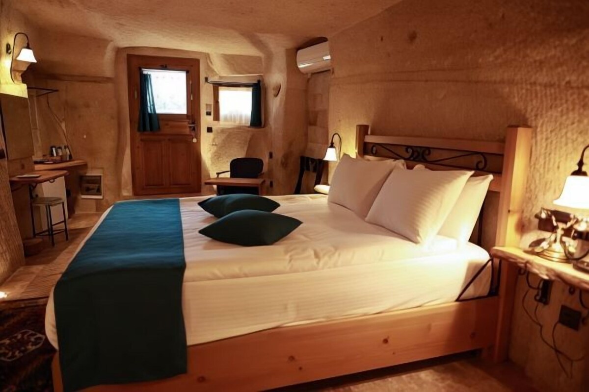 A wooden room with a bed, a desk, and a chair.