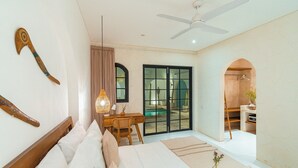 A bedroom with a bed, desk, and a sliding glass door leading to a balcony. - Villa The View (Canggu)