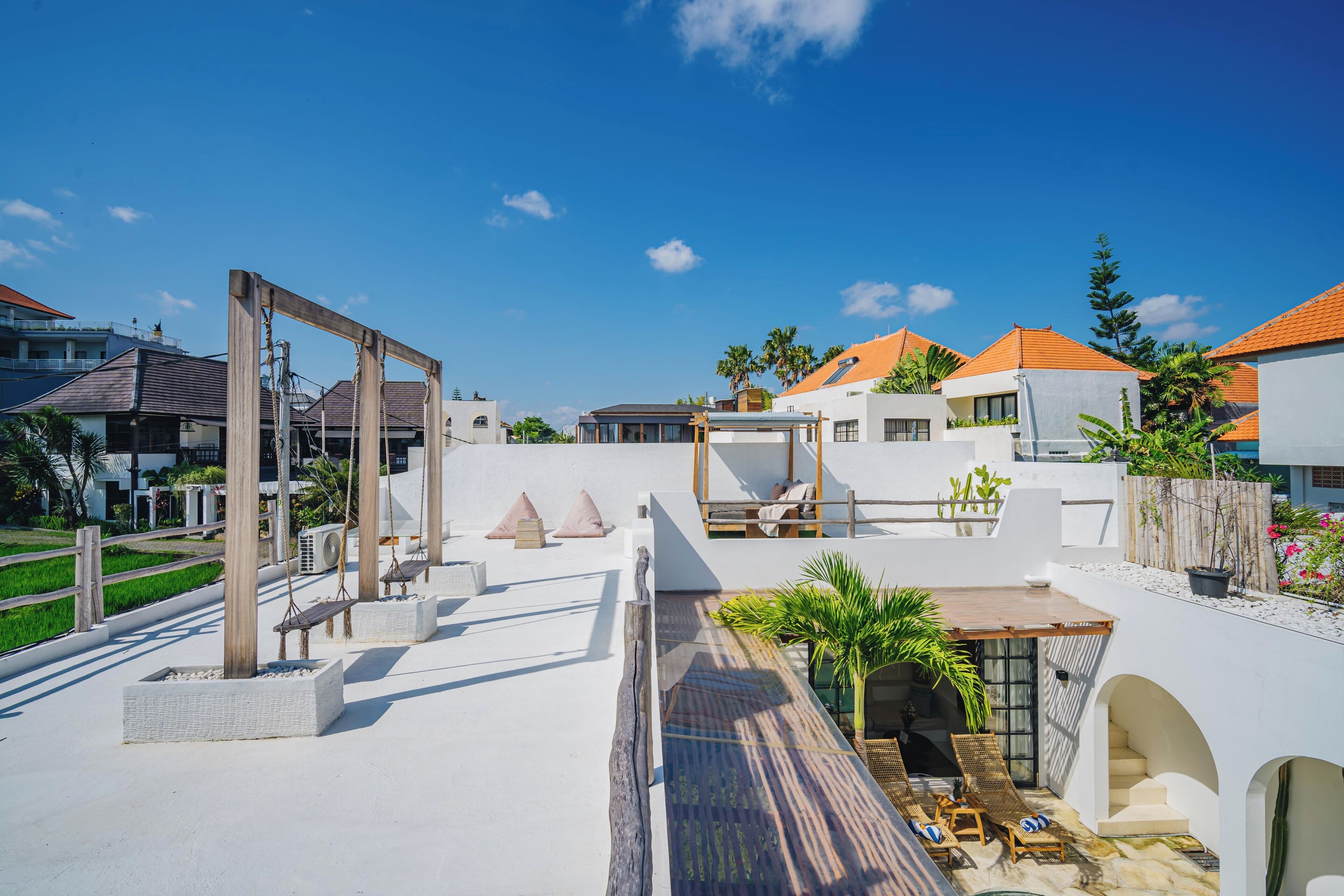 A rooftop terrace with a wooden pergola, seating area, and a small pool.
