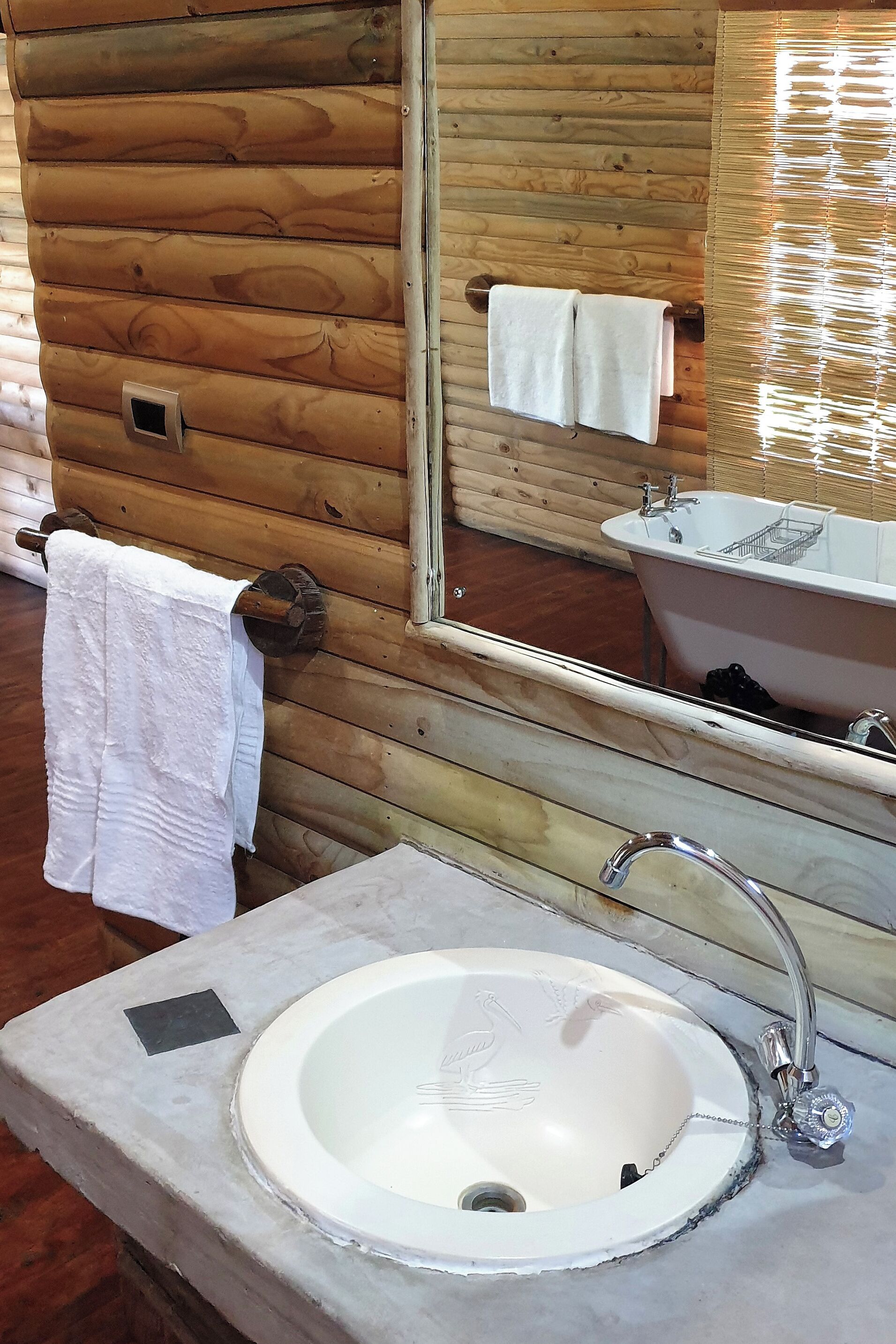 A bathroom with wooden walls, a white sink, and a bathtub.