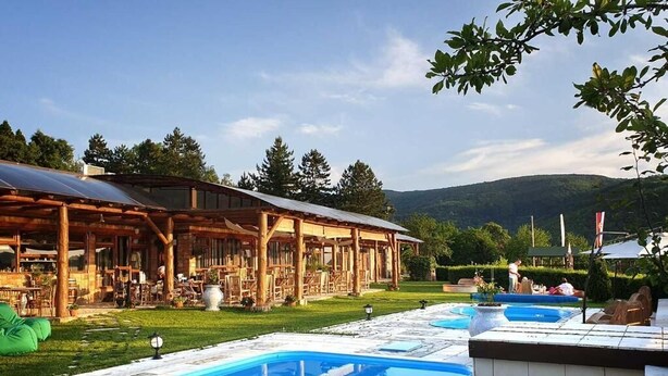 A pool area with a wooden deck and a covered seating area. - Zdravkovac Country Club (Topola)