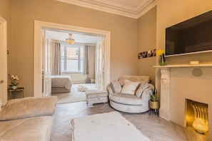 Relax in this stylish living room with a comfortable sofa, flat-screen TV, and fireplace.