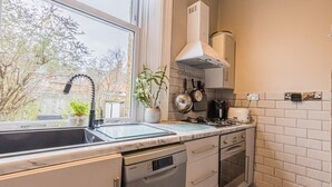 A modern kitchen with a built-in dishwasher, oven, and stove. - Ground Floor 1 Bedroom Flat - Windsor By Tempstay (Berkshire)