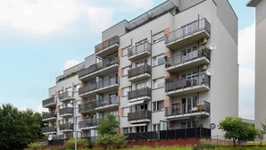A multi-story residential building with balconies, a flat roof, and a modern architectural design.