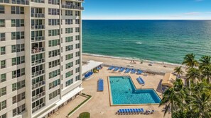 Een hotel met een zwembad, strand en uitzicht op de oceaan.