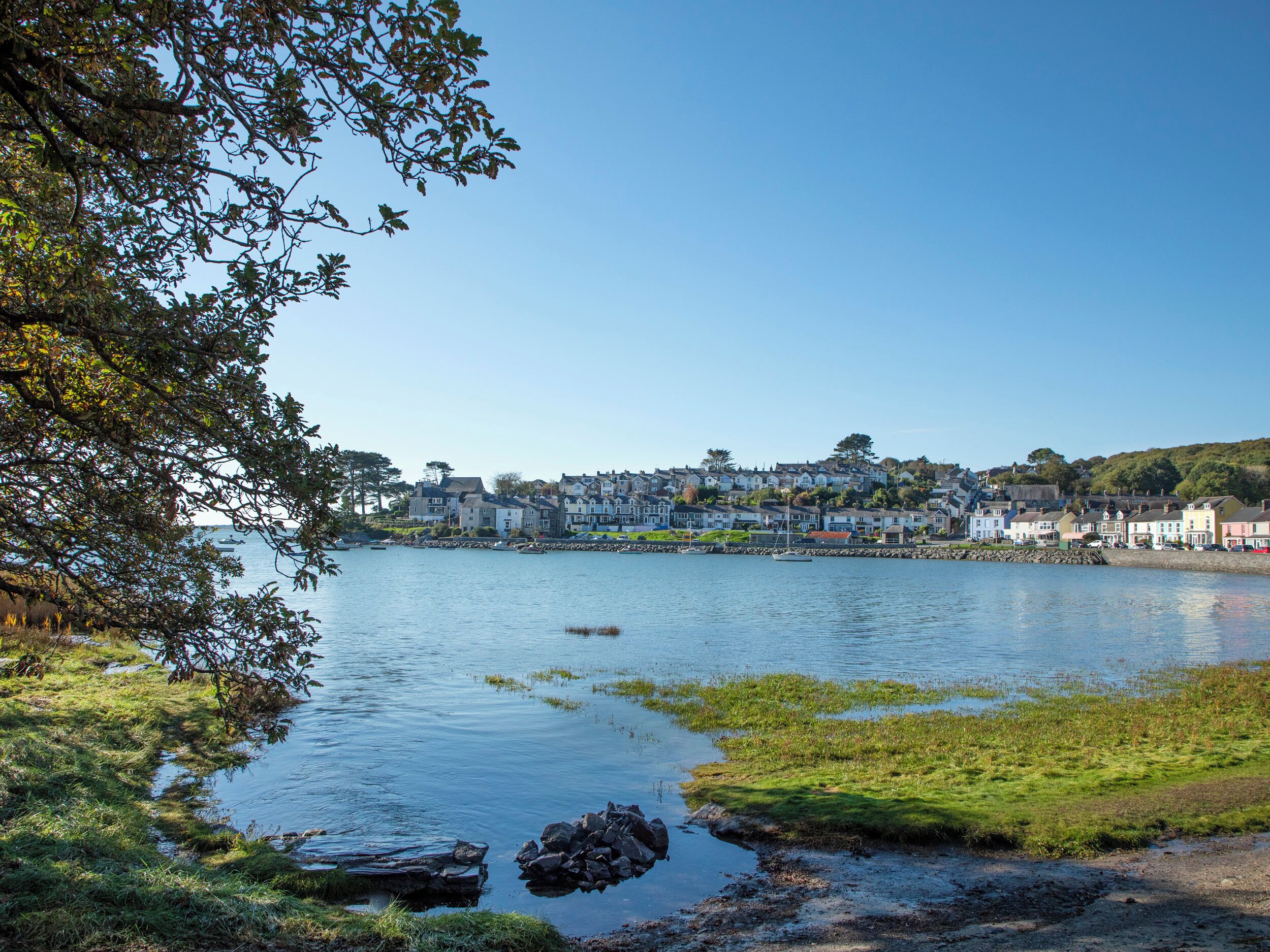 A coastal town with houses along the water's edge.