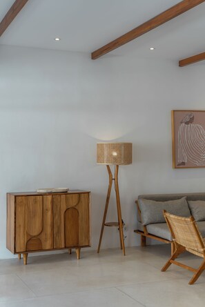 Une pièce avec un meuble en bois, un lampadaire et un canapé.