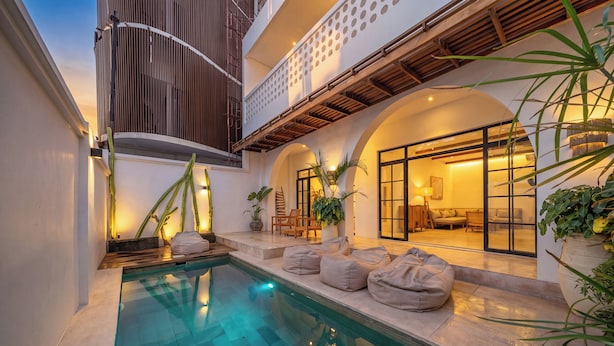 A pool area with a clear pool, seating, and potted plants. - Villa Eliad - 3 Bedroom Villa in Berawa (Canggu)