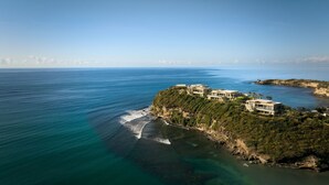 Una propiedad costera con varias construcciones en un acantilado con vistas al mar.