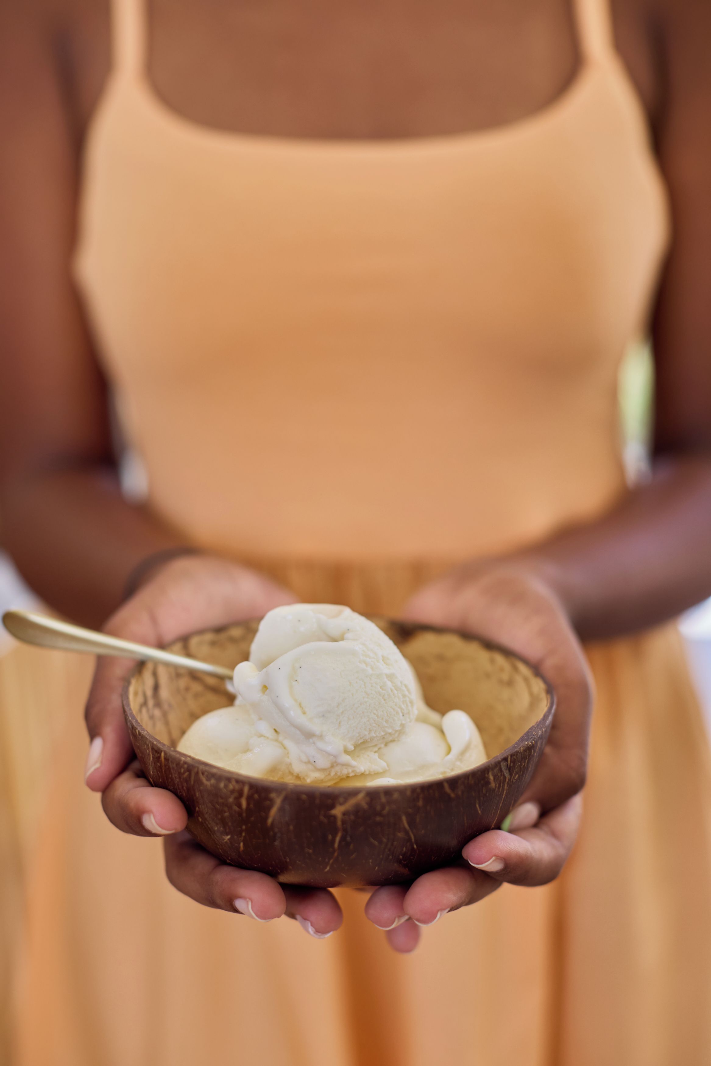 A person holding a bowl of ice cream.