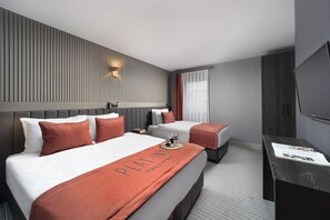 A hotel room with two beds, a flat-screen TV, a nightstand, and a window with curtains. -  Union Hotel Plat Inn (Istanbul)