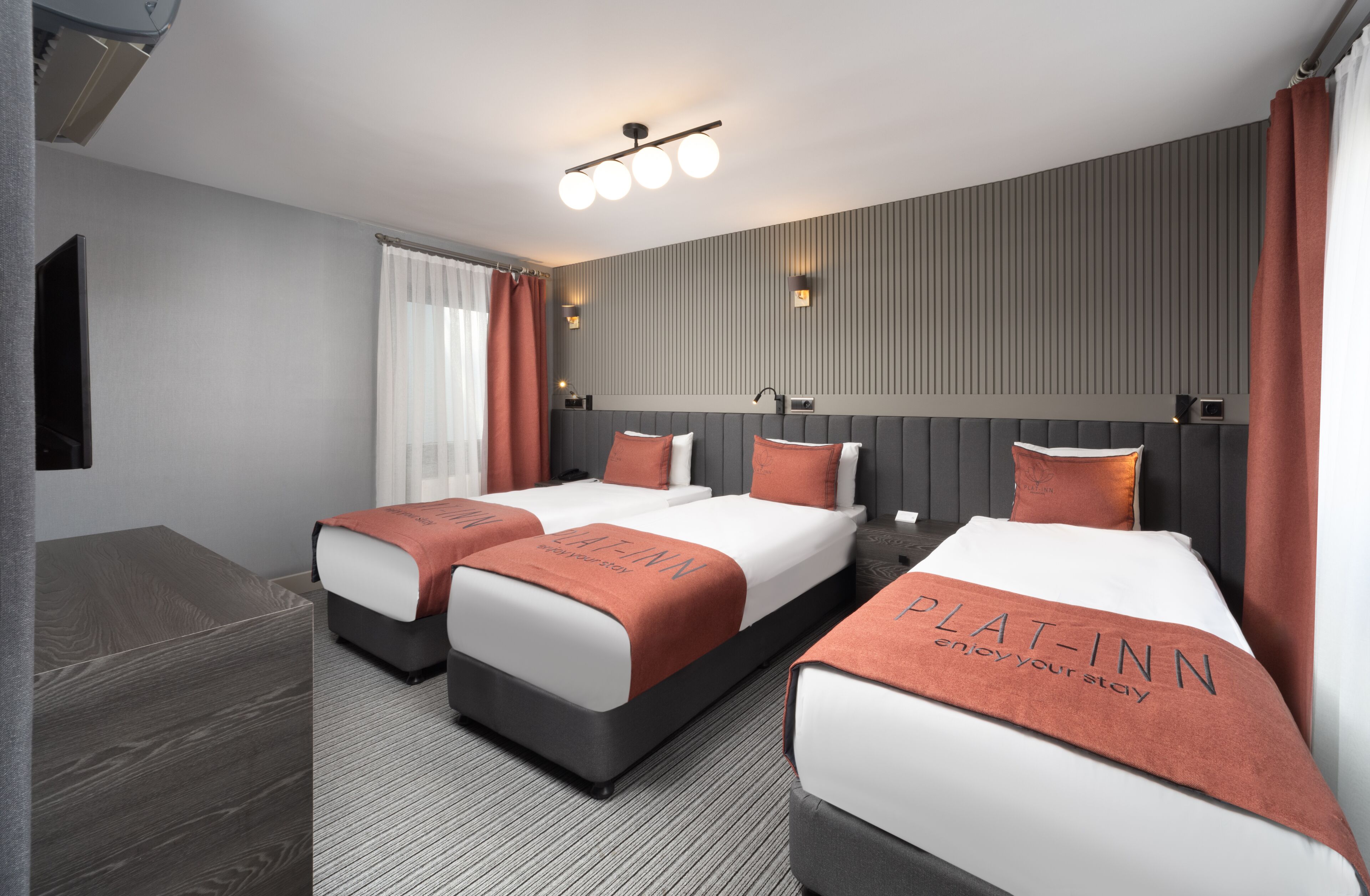A hotel room with two beds, a large mirror, and a modern design.