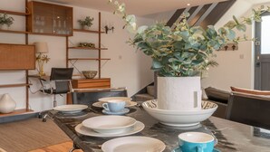 Una cocina moderna con encimera de mármol, cuencos blancos y una planta grande en maceta.